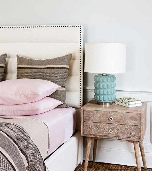 Upholstered, channel headboard, blush pink and charcoal striped bedding. Aqua glass lamp.