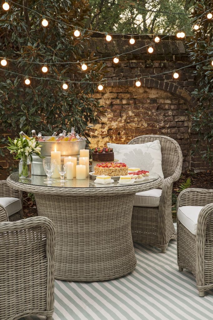 Outdoor patio furniture with string lights and candles