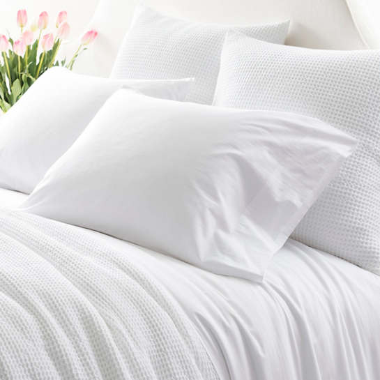 Made of airy cotton, the Essential Percale Sheet Set is a clean, white bedding choice that matches especially well with seaside furniture.