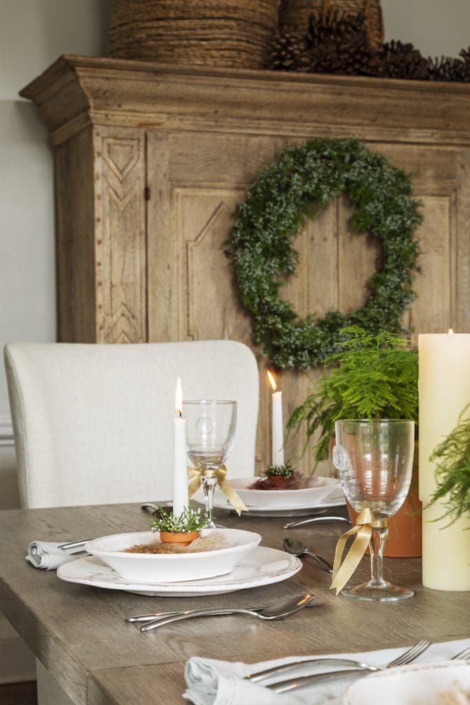 Emerald Green natural accents from wreathes and fern leaves decorate a dining room by Mt Pleasant furniture store GDC