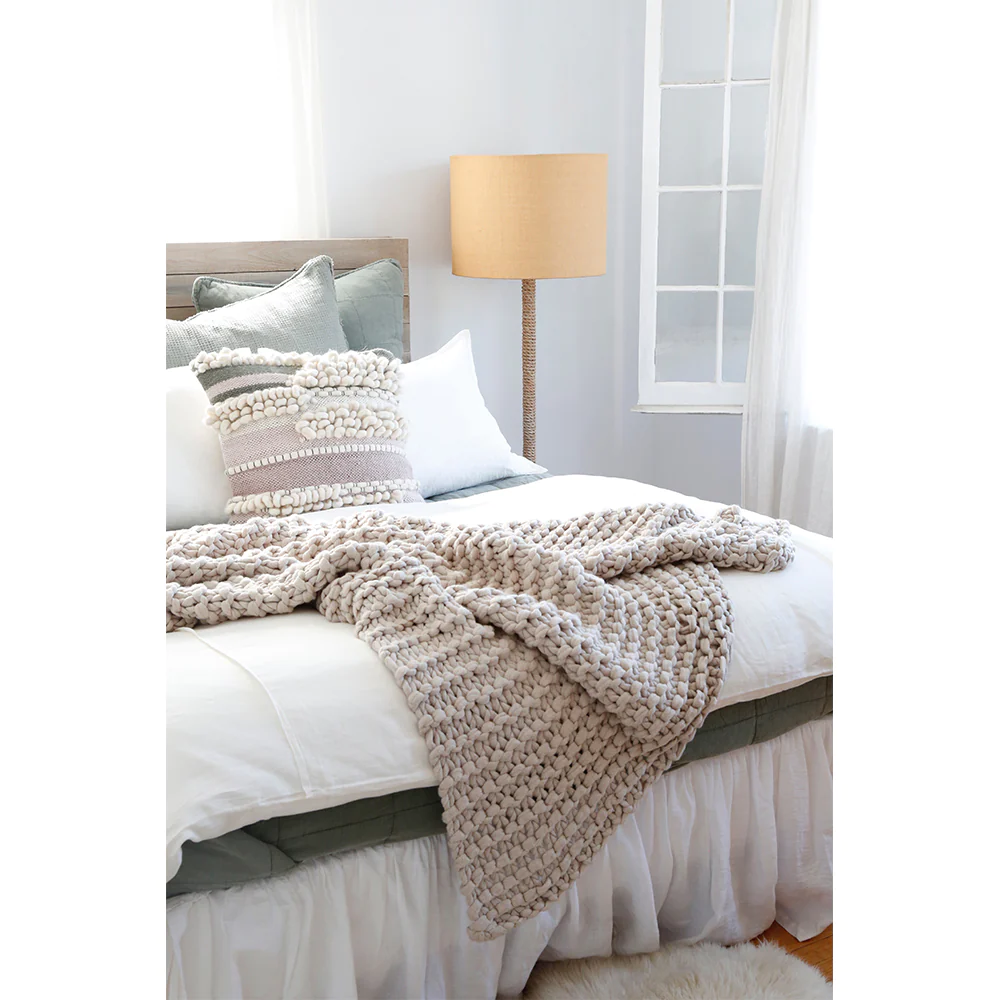 neutral bedroom with throw blanket and textured pillow
