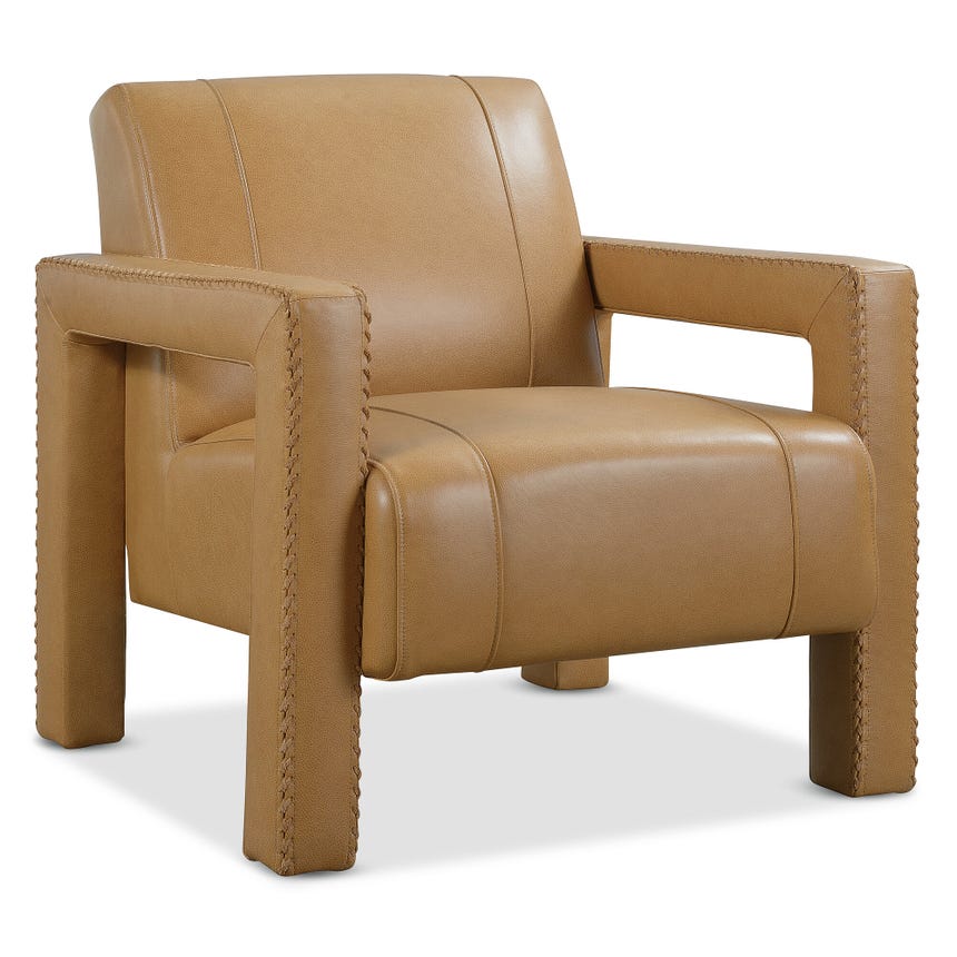angled side view of a tan leather upholstered armchair with sturdy arms and detailed stitching