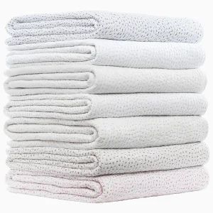 stack of quilts with different colored stitching