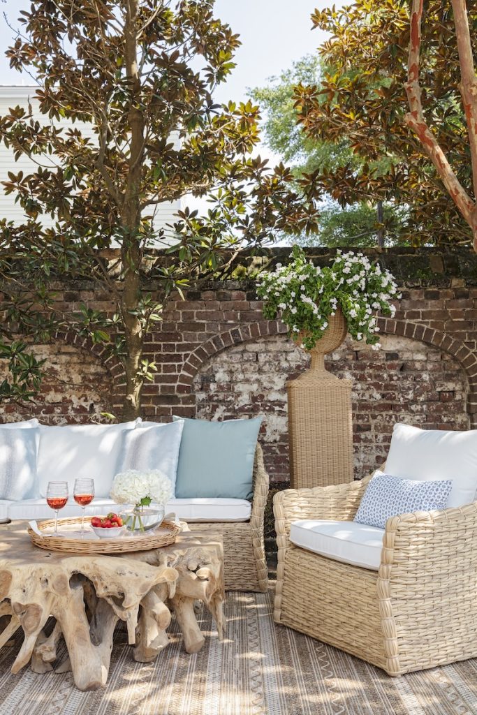 outdoor living space with resort-style patio furniture, including a natural wood coffee table from one of the best furniture stores in Charleston