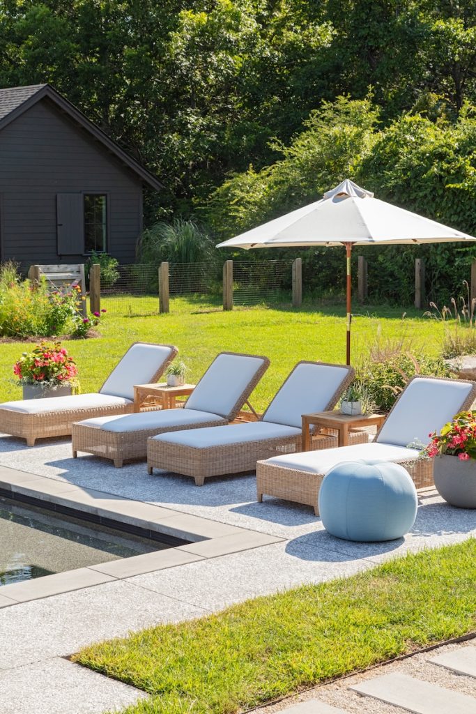 cushioned outdoor chaise lounge chairs arranged poolside in a Charleston outdoor living space