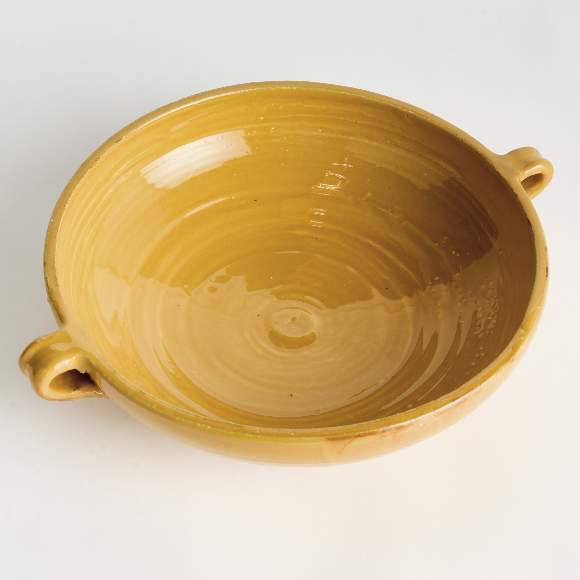 decorative terracotta bowl with handles and golden ochre glaze