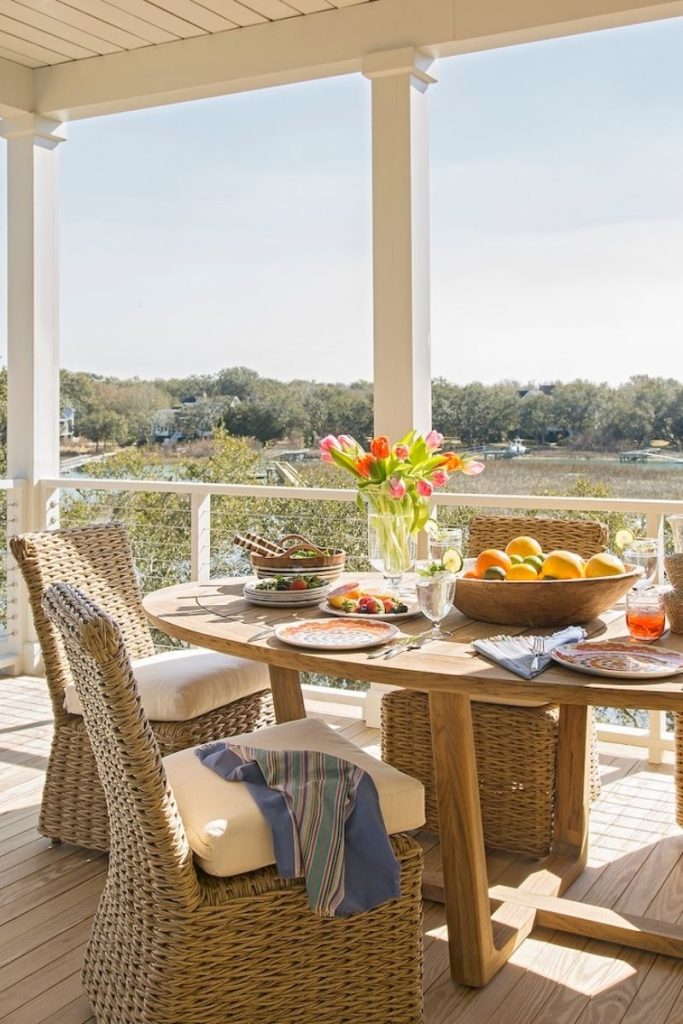 A sunlit waterside outdoor dining area on a Lowcountry patio, styled with outdoor furniture and tabletop pieces from charleston home furniture store GDC — one of our favorite small outdoor space ideas