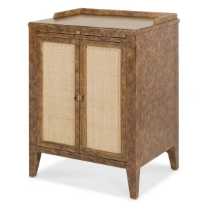 A Mottled Amber faux-tortoise shell finish with woven cane door fronts features a pull-out tray and a gallery rail on top. Sits low to the ground.