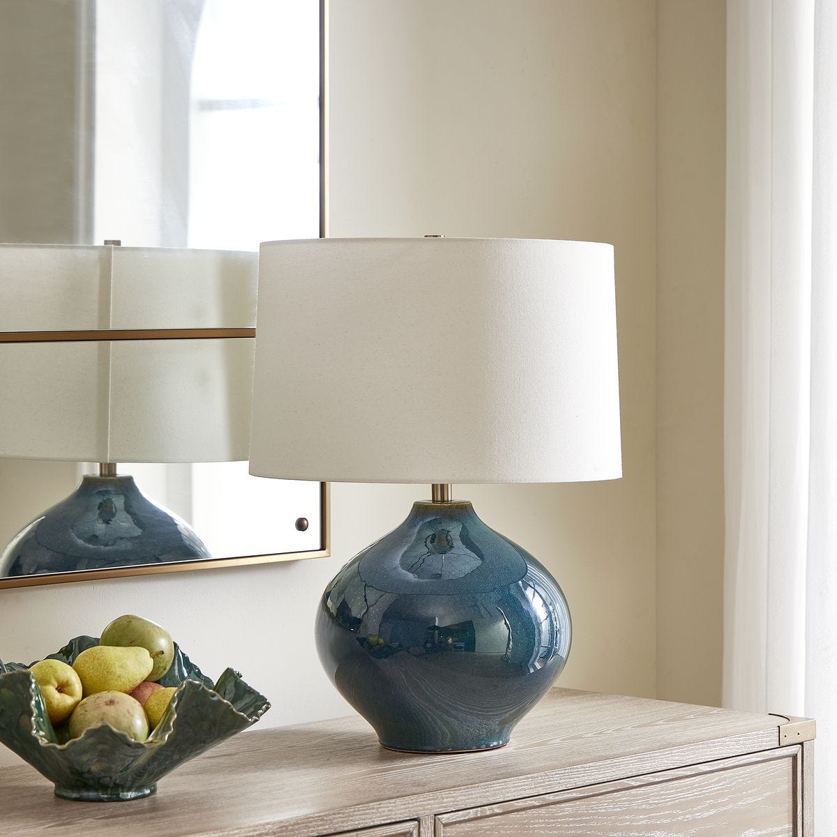 lifestyle image of round table lamp in deep blue finish with white shade