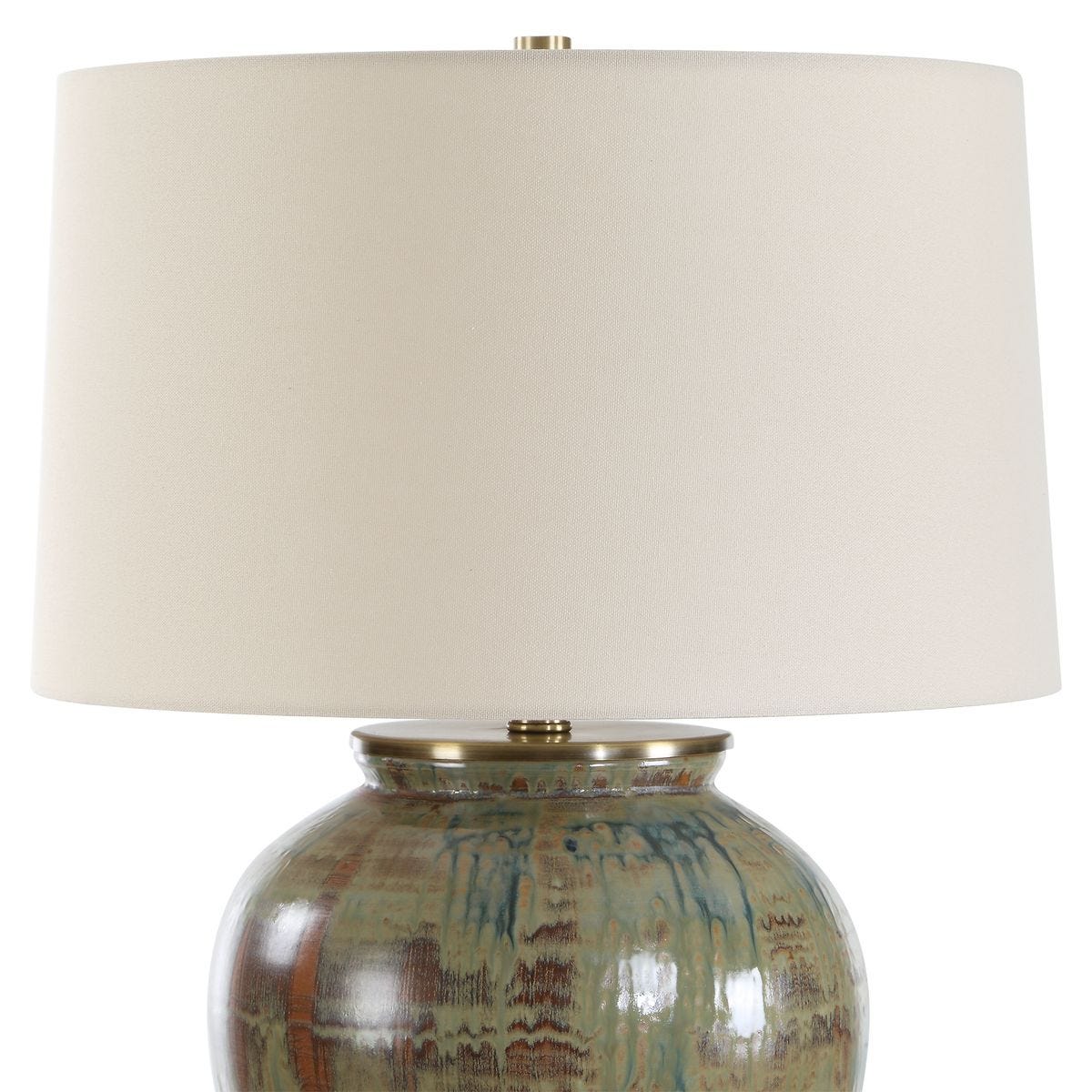 detail of table lamp with urn base finished in shades of green, blue-green, and earthy browns and an off white shade, brass accents