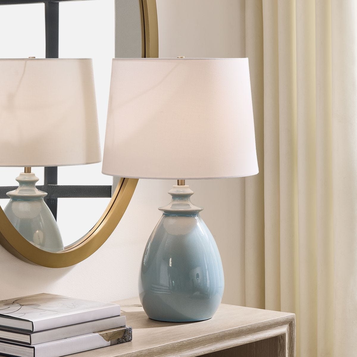 lifestyle image of table lamp in light blue glaze with white shade