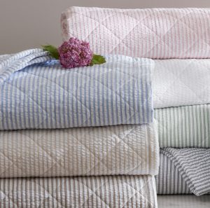 stack of folded seersucker quilts in all colors