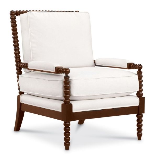 A white upholstered chair with detailed dark woodwork