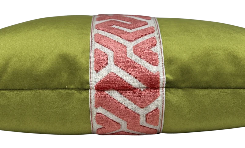 Side view of olive green velvet lumbar pillow with a pink geometric embroidered center band