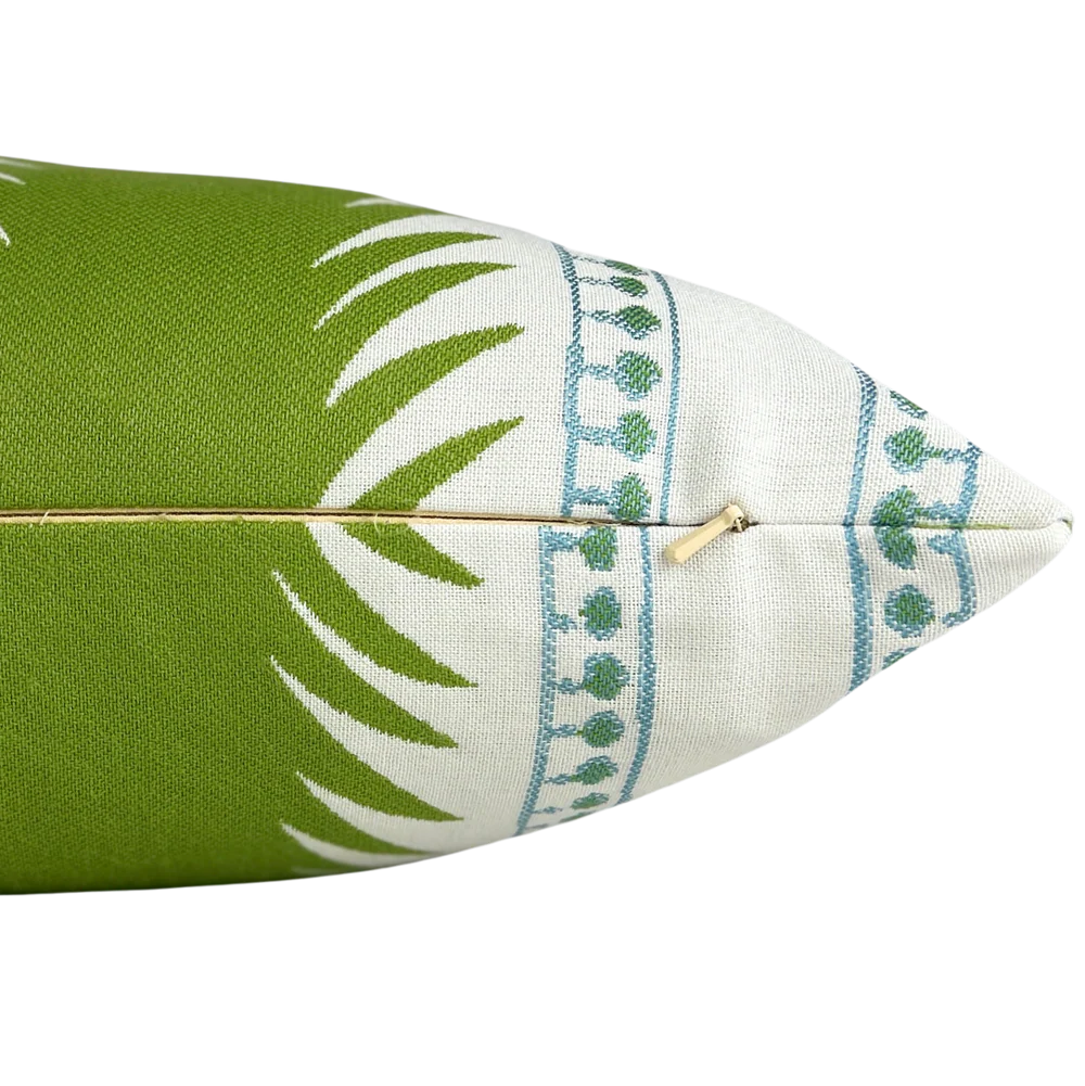 detail of outdoor decorative pillow with bold green botanical-inspired stripes and delicate blue accents