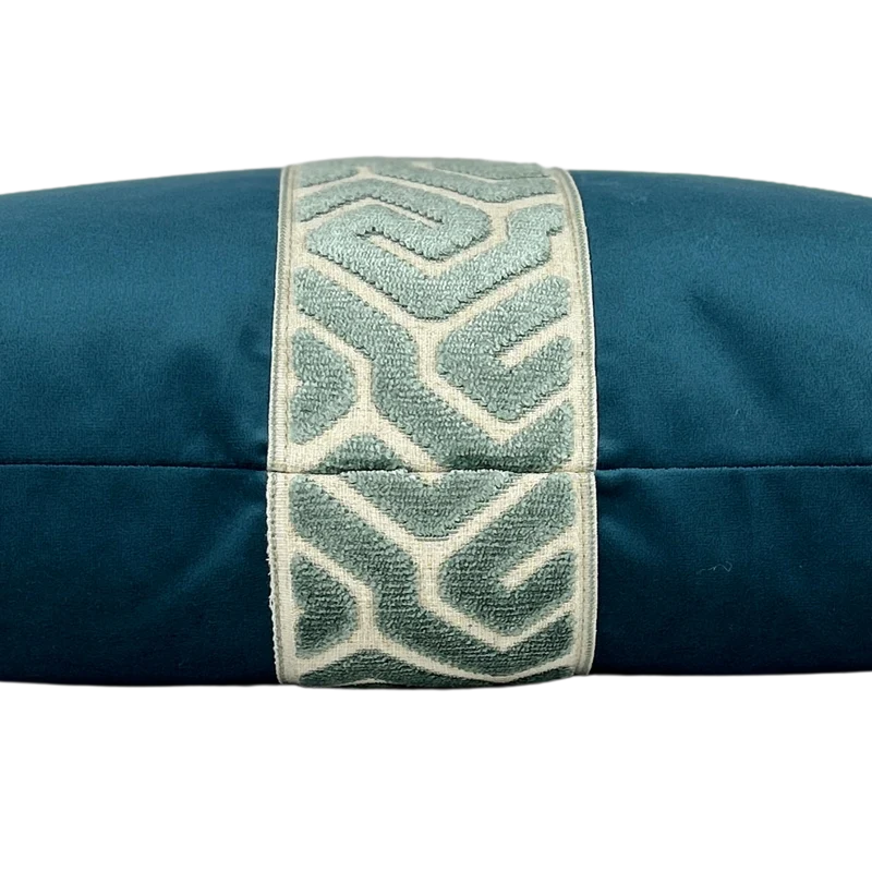 Side view of navy velvet lumbar pillow with a aqua geometric embroidered center band