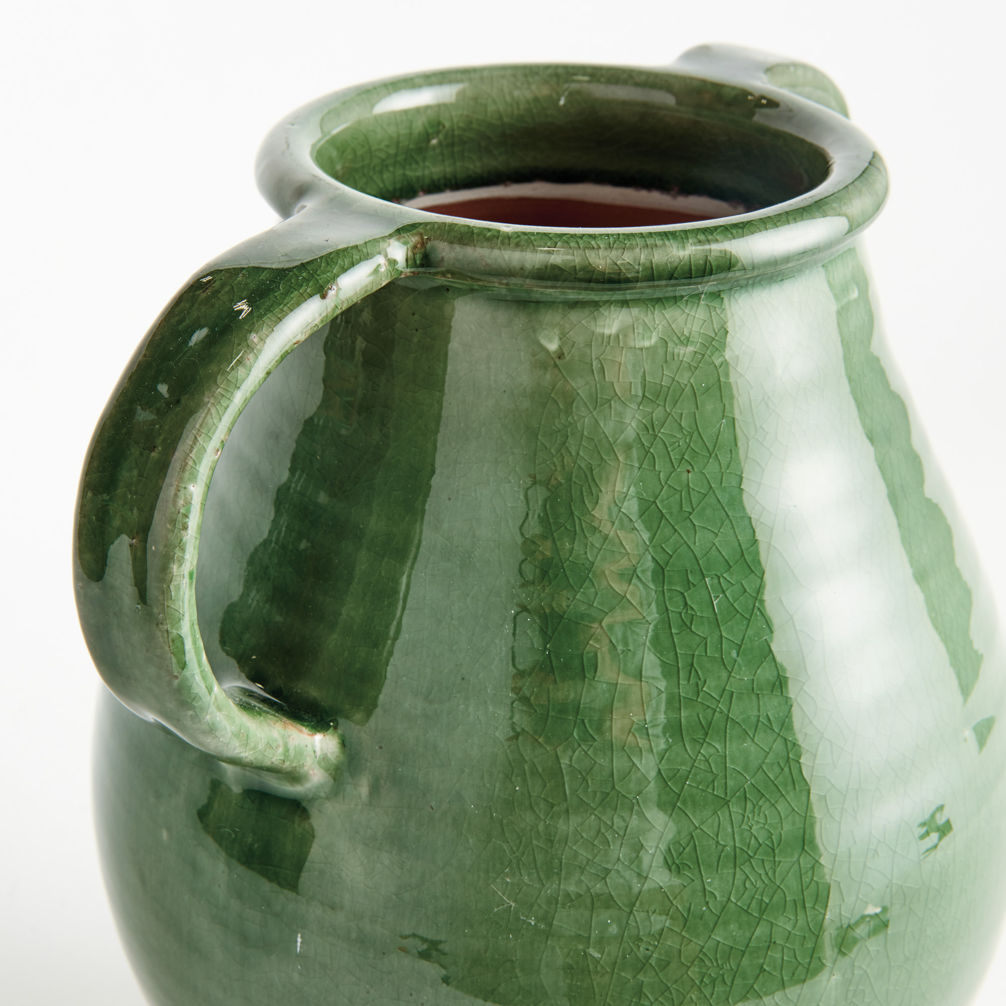 detail of decorative terracotta vase with handles and green glaze, crackle glaze