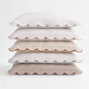 stack of five scalloped linen lumbar pillows in different colorways