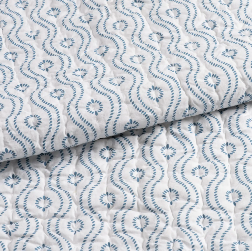 detail of blue block print bedding, dotted wave