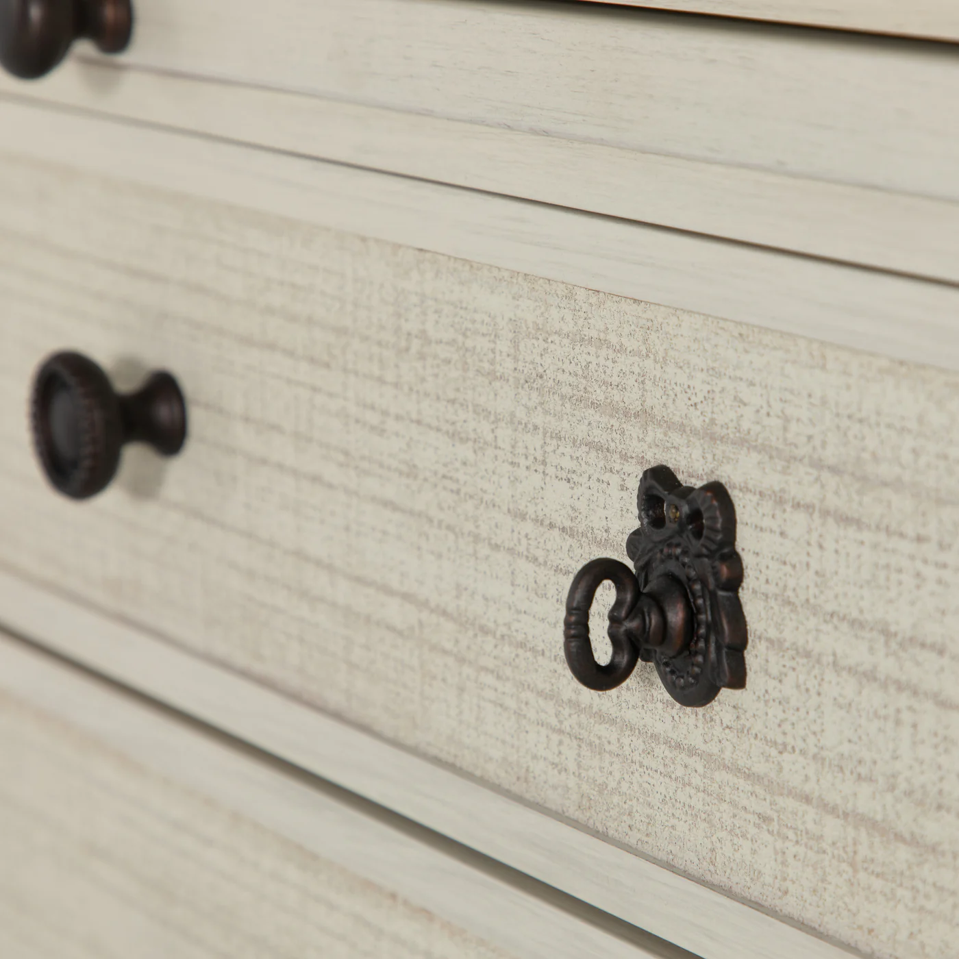 detail of three drawer low profile dresser with linen front drawers in antique white finish, dark antique bronze hardware