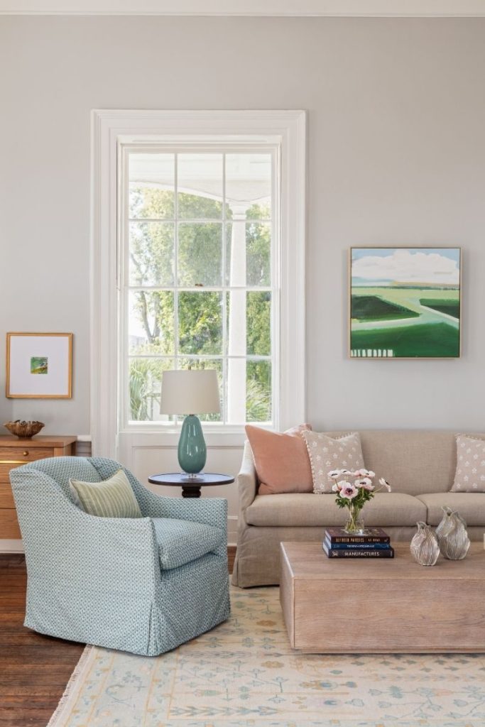 A light blue patterned swivel accent chair styled in an airy living room with the coastal home decor charleston sc is known for, sourced from GDC Home
