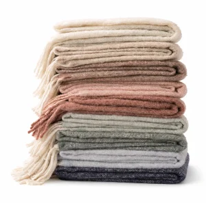 stack of faux mohair throws in soft pastel and neutral tones