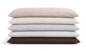 stack of extra long decorative lumbar pillows with eyelash fringe in neutral tones