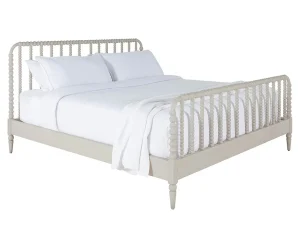 spindle design bed in antique white finish made up in white linens