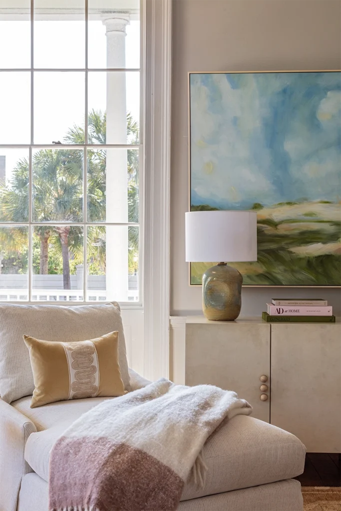 The 2026 bedroom design trend of an accent chair styled into a reading nook by the window of a coastal bedroom, styled with Charleston home furniture from GDC Home