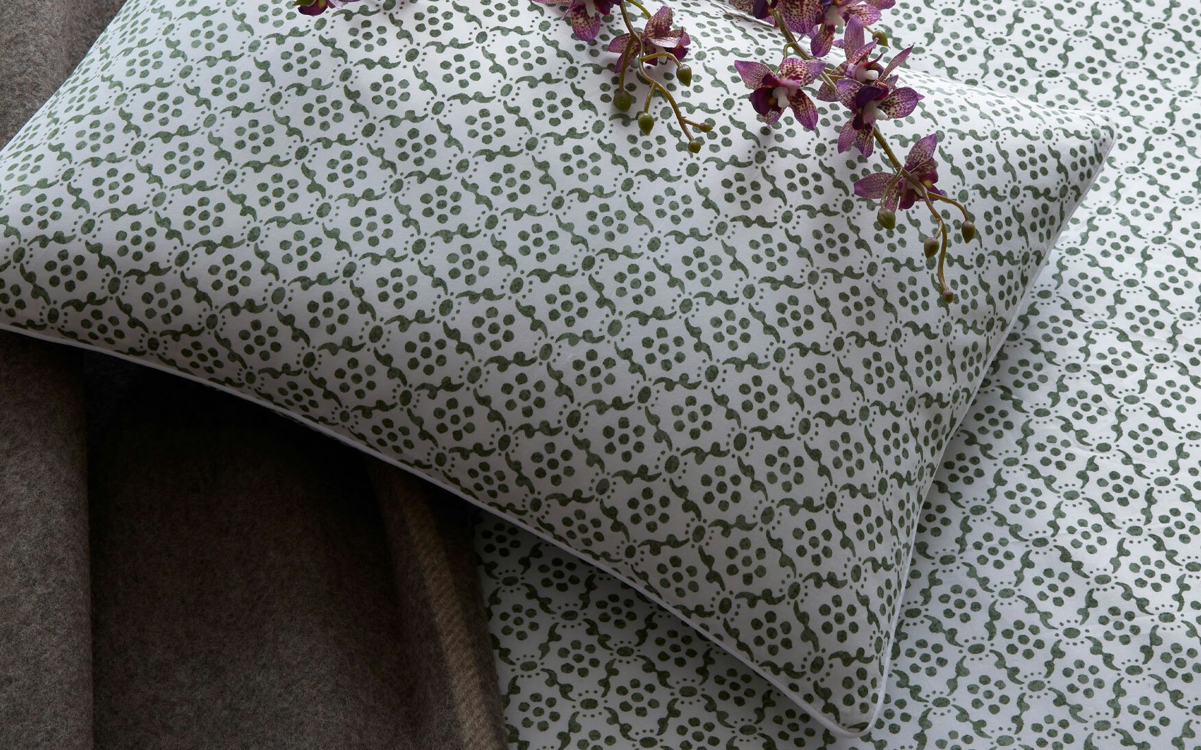 detail of a pillow sham with small scale indian block print motif in olive green