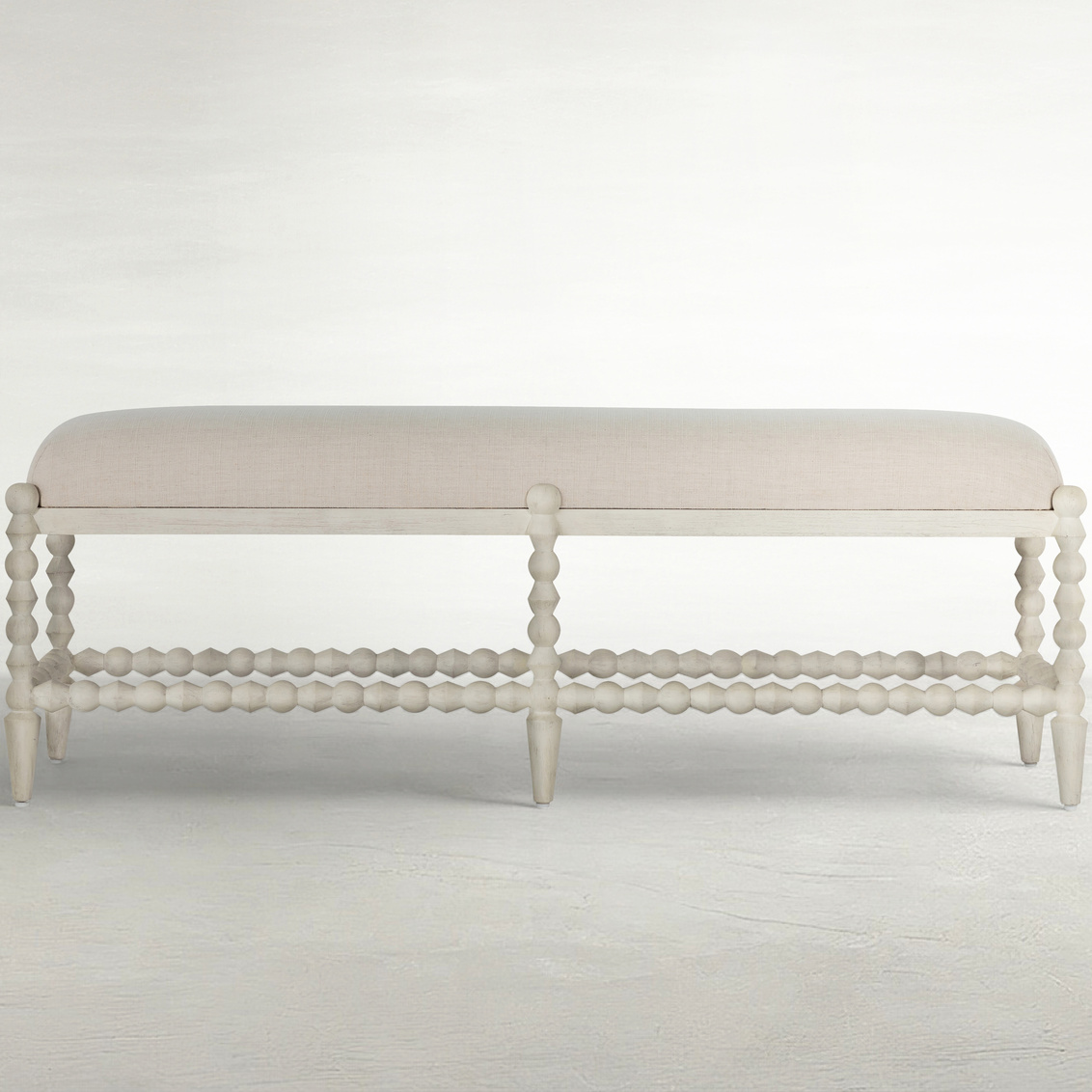 rectangular bench with bobbin style frame and neutral upholstered top
