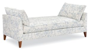 daybed upholstered in a light blue and cream woodland animal fabric with brown legs