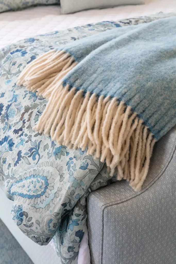 bedding layers at the foot of a styled bed