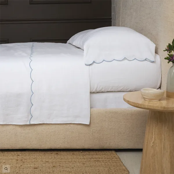 A white linen sheet set with scalloped edges